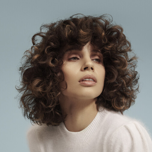 Woman with curly hair and precision cut, styled with OWAY Organic Way products.