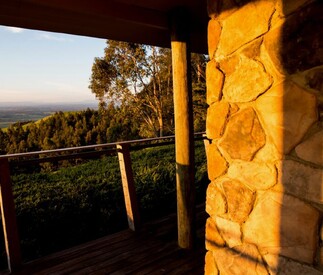 deck with timber posts and stonework on chimney