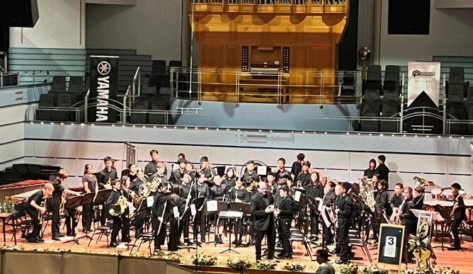 Wind band on stage standing with their instruments