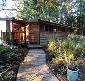 The new beach house design replaces the existing triangular shack and is placed to avoid native vegetation and rock features.