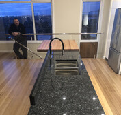 Custom kitchen design featuring two-pac painted panels, honed black and polished Blue Pearl granite, and Tassie Oak butcher block to match the flooring.