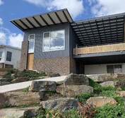 Front yard extension featuring brick, corrugated metal siding, timber screen wall, UPVC windows and bluestone landscaping.