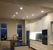 Custom kitchen design featuring two-pac painted panels, honed black and polished Blue Pearl granite, and Tassie Oak butcher block to match the flooring.