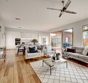 View looking onto wood decked veraInterior view showing kitchen, dining and living area with hardwaood flooring and marble benchtops.Living Room extension and veranda.