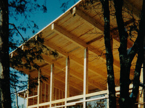 Construction progress view from Southeast showing heavy timber cedar post & beam construction with pine tongue & groove roof decking.