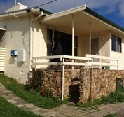 View of 1950 single storey brick house. Previous Condition: front porch and carport were removed for the front yard extension.