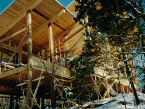 Construction progress view from Southwest showing heavy timber cedar post & beam construction with pine tongue & groove roof decking.
