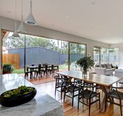 Interior view looking across Carrara marble benchtop to living, dining and veranda. Living Room extension and veranda.