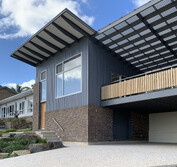 Front yard extension featuring brick, corrugated metal siding, timber screen wall, UPVC windows and bluestone landscaping.