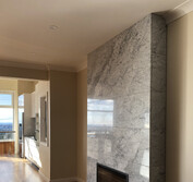 Gas fireplace with polished Carrara marble and honed black hearth.