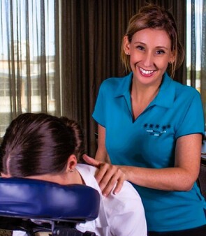 Seated Massage therapist from Mobile Healing Hands providing massage on seated massage chair