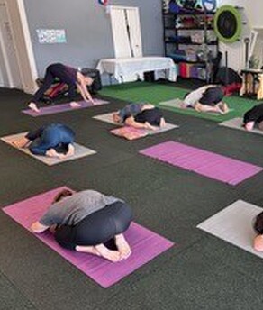 Yoga teacher taking a small class