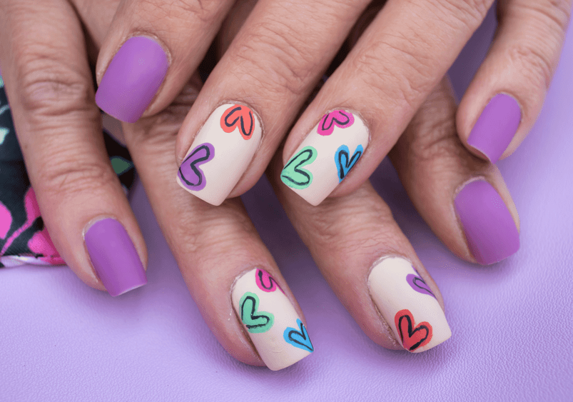 Image of hand with pastel coloured nails and love hearts at Princess Nails Spa and Beauty