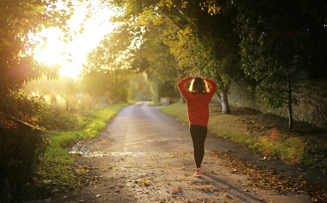 Woman walking self-reflectively along road
