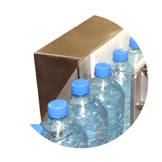 Bottles on conveyor belt running through air knives which are removing surface moisture (air blower technology)