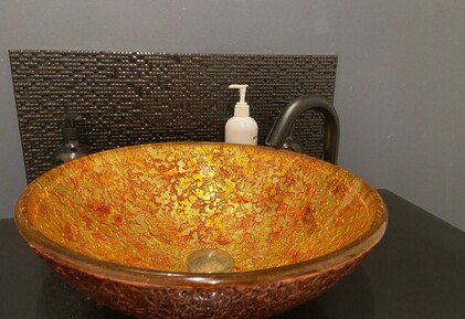 the ET2-OL24.1 Gooseneck tap finished in gunmetal and installed with a raised glass basin