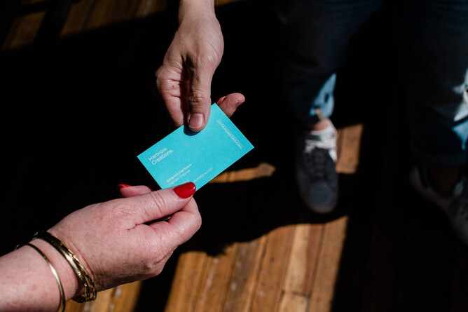 Amanda Harbrow handing a business card to a potential client of Brisbane